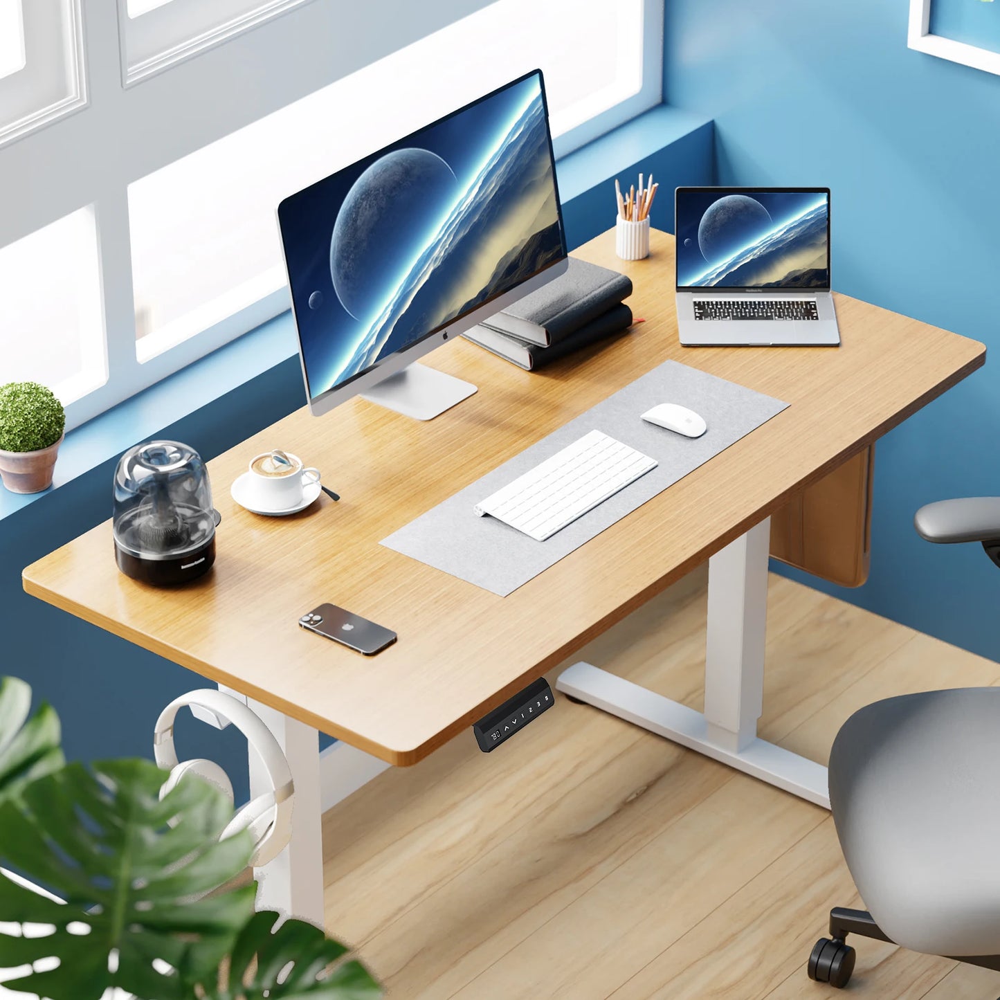 JHK electric standing desk with wooden top in a home office with a blue accent wall